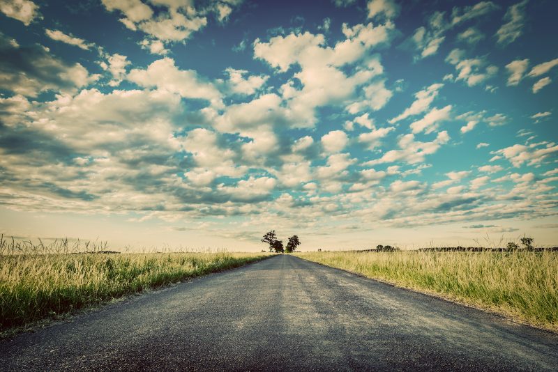 Empty straight long asphalt road. Dramatic cloudy sky. Concepts